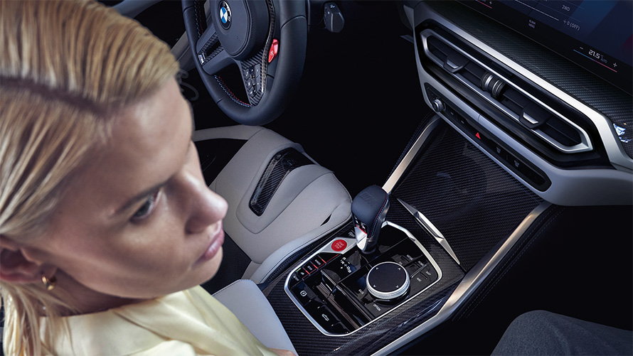 BMW M4 Competition Cabrio ar M xDrive, G83, 2021, viduskonsole BMW M4 Competition Cabrio ar M xDrive, G83, 2021, viduskonsole, sieviete pasažiera sēdeklī
