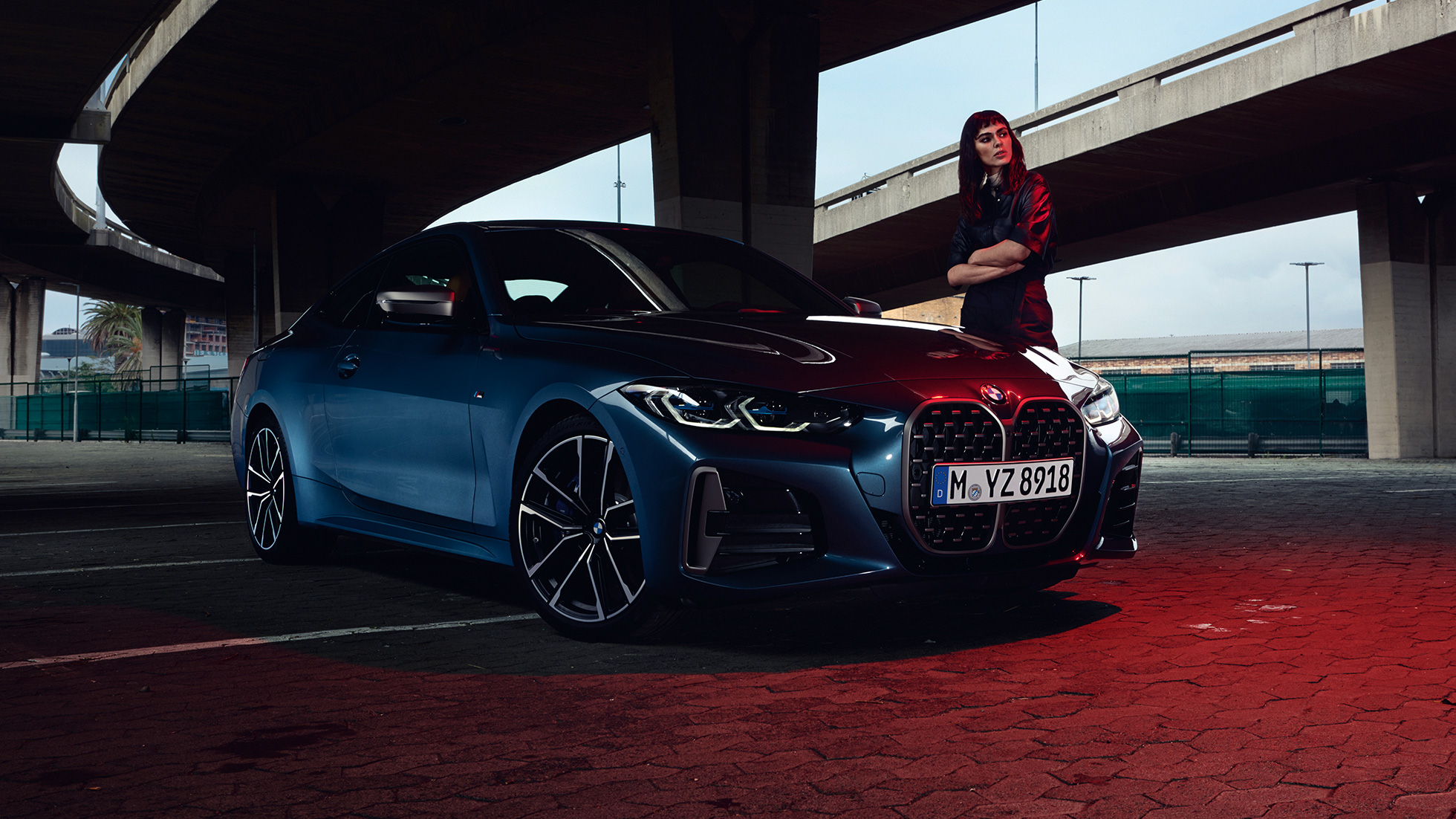 Modelis, kas stāv blakus BMW M440i xDrive Coupé, G22, 2020, trīs ceturtdaļu sānskats BMW M440i xDrive Coupé, metāliska Arctic Race Blue krāsa, G22, 2020, trīs ceturtdaļu sānskats ar modeli