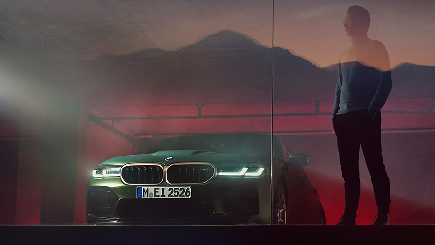 BMW M5 CS, F90, 2021, priekšpuses skats ar vīrieti BMW M5 CS, F90, 2021, metāliska Frozen Deep Green krāsa, priekšpuses skats ar vīrieti