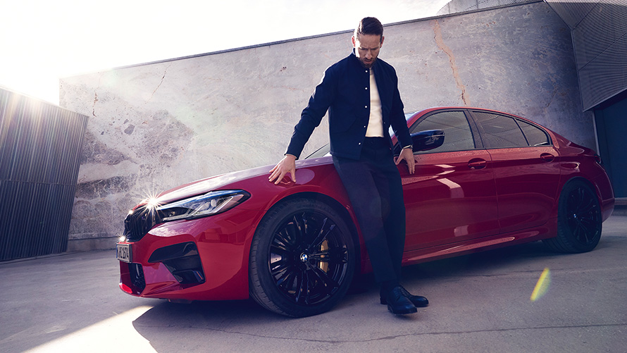 BMW M5 Competition, F90, LCI, atjaunināts, 2020, BMW Individual Imola Red krāsa, trīs ceturtdaļu priekšpuses skats ar vīrieti