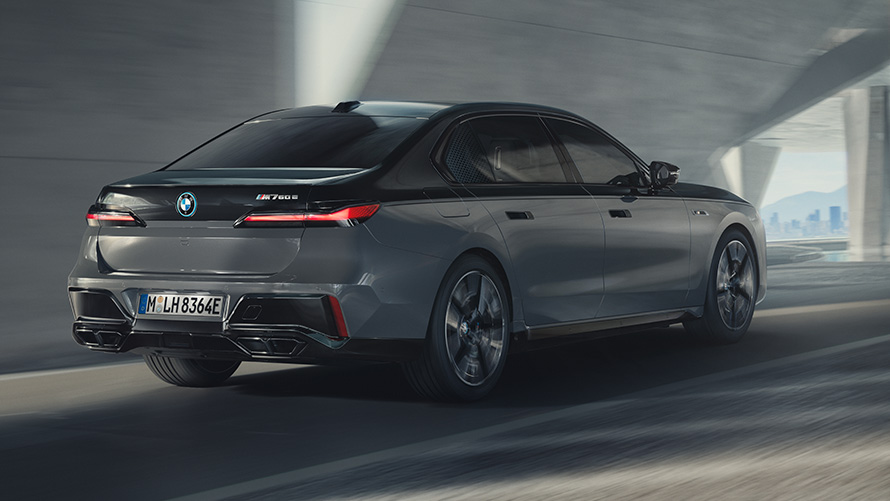 BMW M760e xDrive Sedan, G70, M Performance pakotne BMW M760e xDrive Sedan, G70, M Performance pakotne, BMW Individual divtoņu metālisks Black Sapphire krāsojums, BMW Individual metāliska Dravite Grey krāsa, trīs ceturtdaļu aizmugures skats, braucienā pa ielu