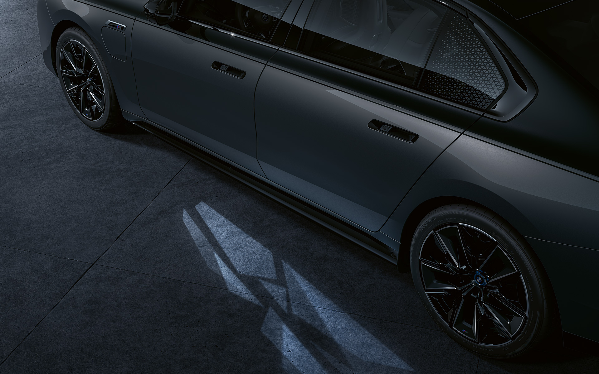 Apgaismojuma koncepcija, BMW M760e xDrive Sedan, G70, BMW Individual divtoņu metālisks Black Sapphire krāsojums, BMW Individual metāliska Dravite Grey krāsa, sānskats, tuvplāns, ar ieslēgtu sagaidīšanas apgaismojuma paklājiņu