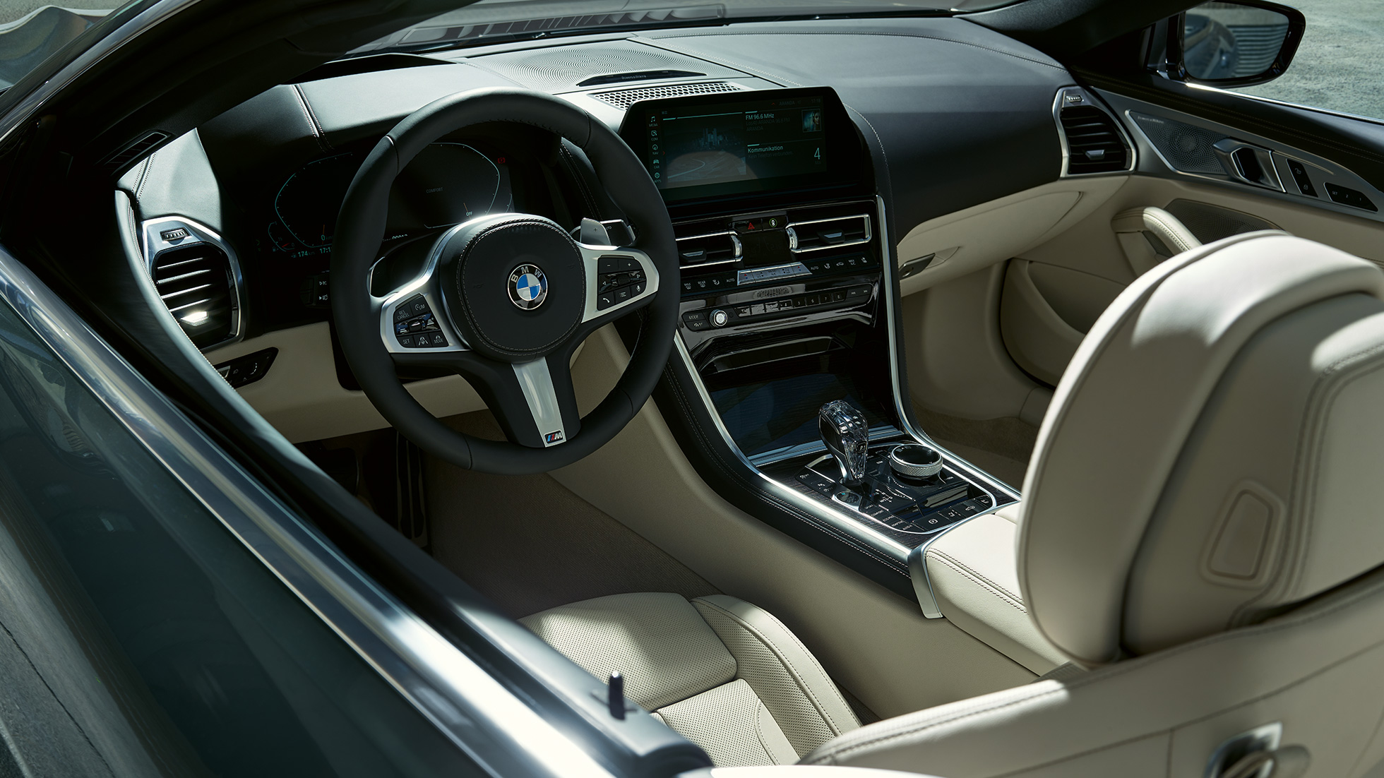 BMW M850i xDrive Cabrio, kokpits. BMW M850i xDrive Cabrio, metāliskā Dravit Grey krāsā ar nolaistu mīkstā seguma jumtu ar M ādas stūri.