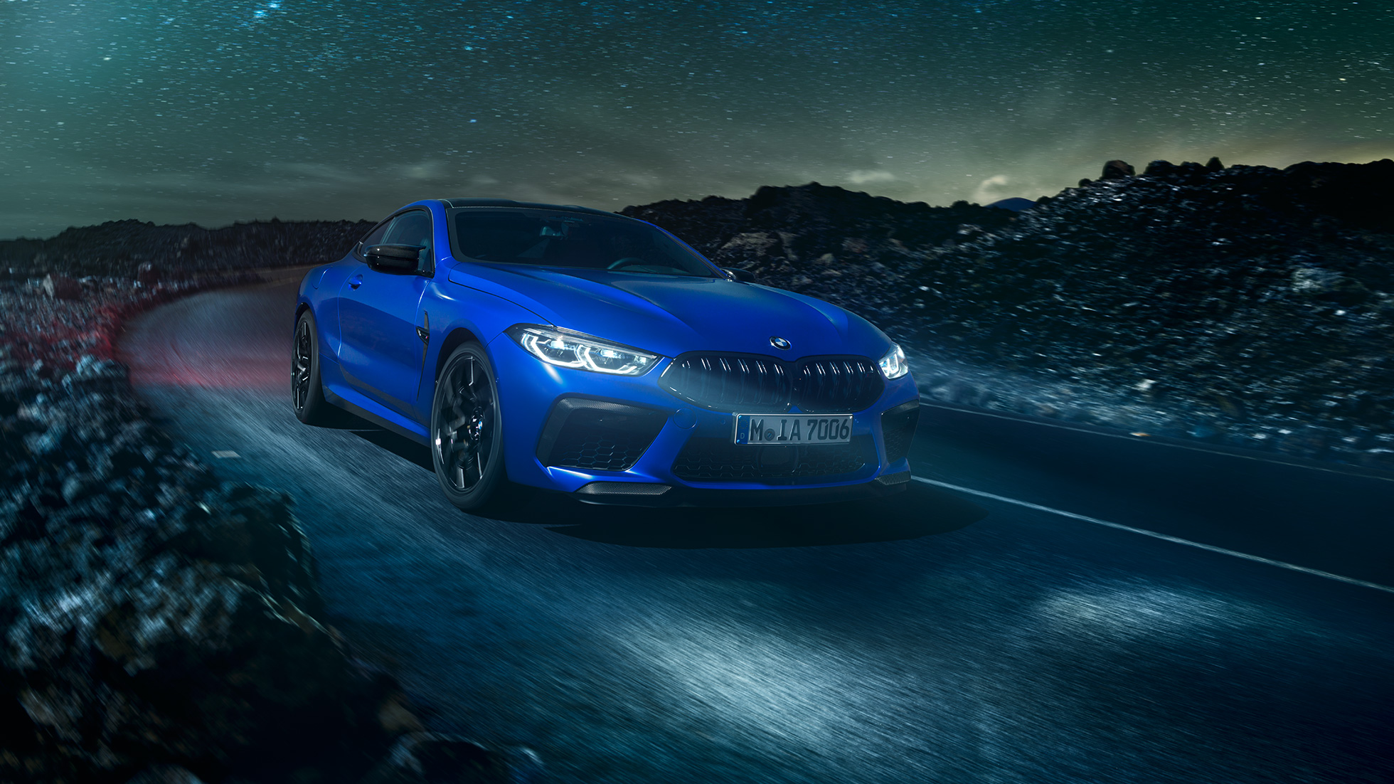 BMW M8 Competition Coupé, skats no sāniem. BMW M8 Competition Coupé metāliskā Marina Bay Blue krāsā, skats no sāniem uz stāvošu automobili uz tuksneša fona pilnmēnesī.