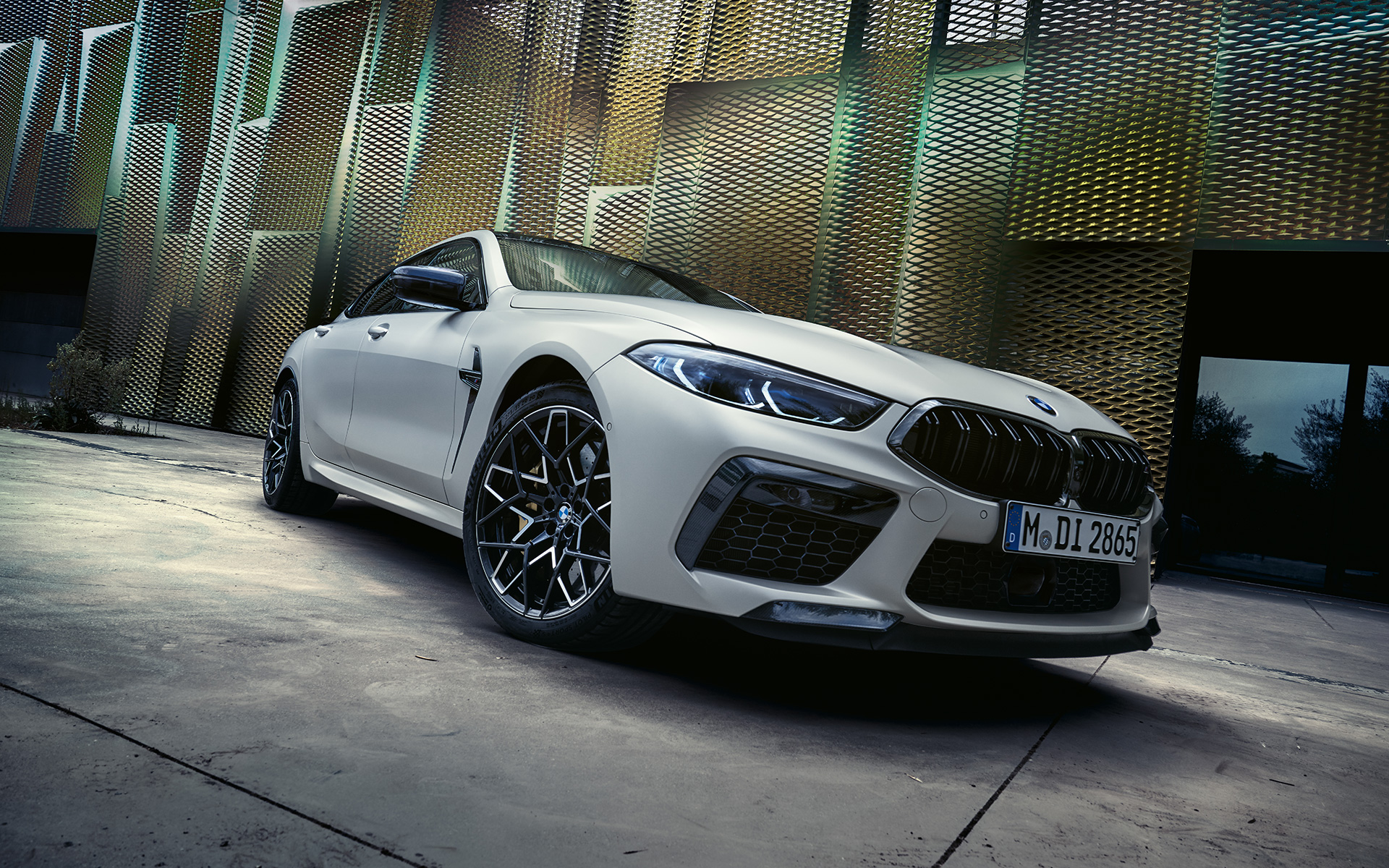 Jaunā BMW M8 Competition Gran Coupé F93, LCI, atjaunināts, 2022, BMW Individual metāliska Frozen Brilliant White krāsa, trīs ceturtdaļu priekšpuses skats, zema leņķa uzņēmums