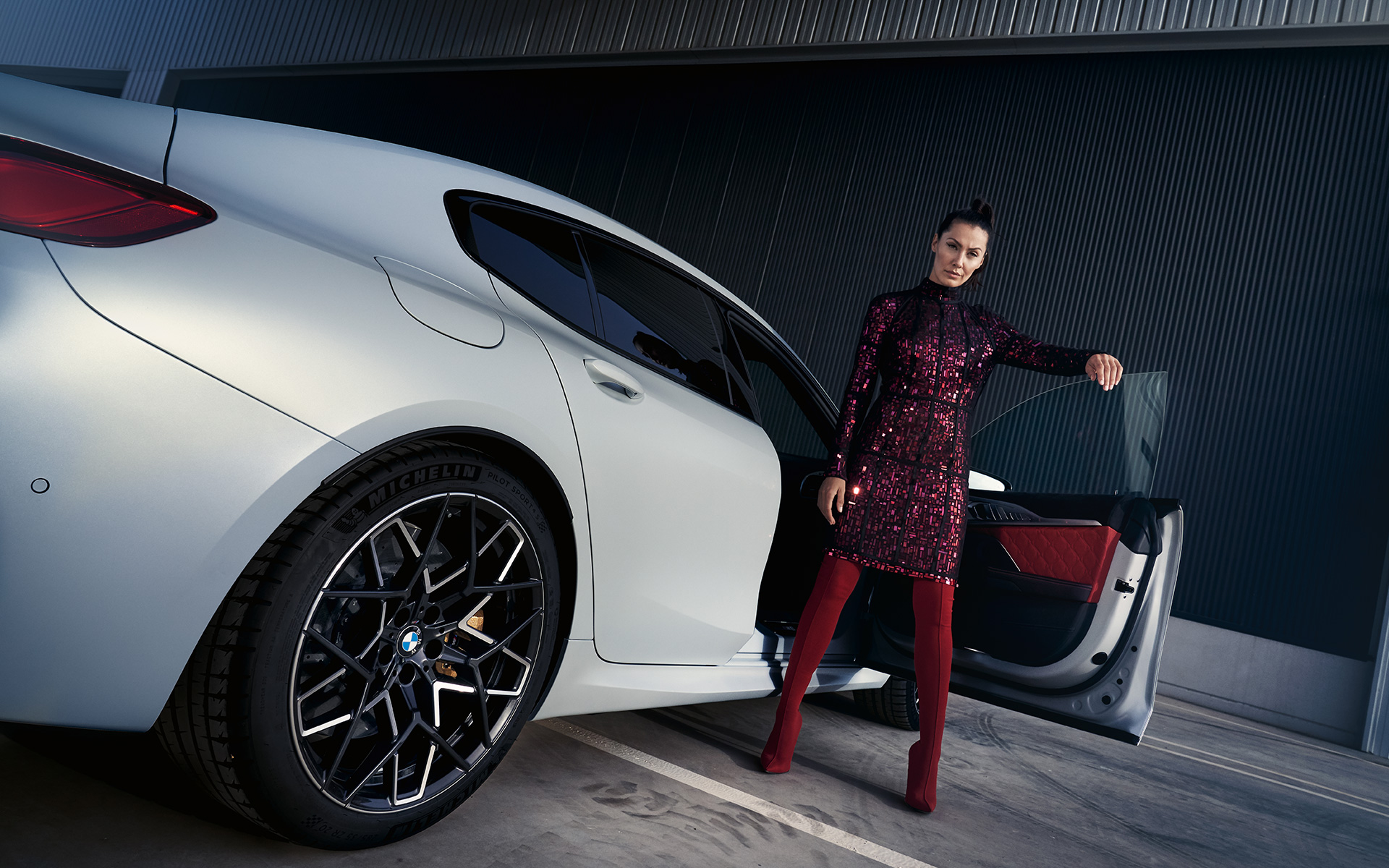 Jaunā BMW M8 Competition Gran Coupé F93, LCI, atjaunināts, 2022, BMW Individual metāliska Frozen Brilliant White krāsa, trīs ceturtdaļu aizmugures skats, ar modeli, zema leņķa uzņēmums