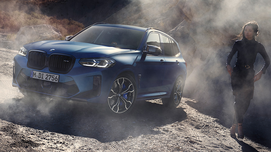 BMW X3 M Competition, F97, LCI, 2021, trīs ceturtdaļu priekšpuses skats, akmeņainā apvidū stāvošs automobilis BMW X3 M Competition, F97,LCI, atjaunināts, 2021, metāliska Frozen Marina Bay Blue krāsa, trīs ceturtdaļu priekšpuses skats, akmeņainā apvidū stāvošs automobilis ar sievieti modeli