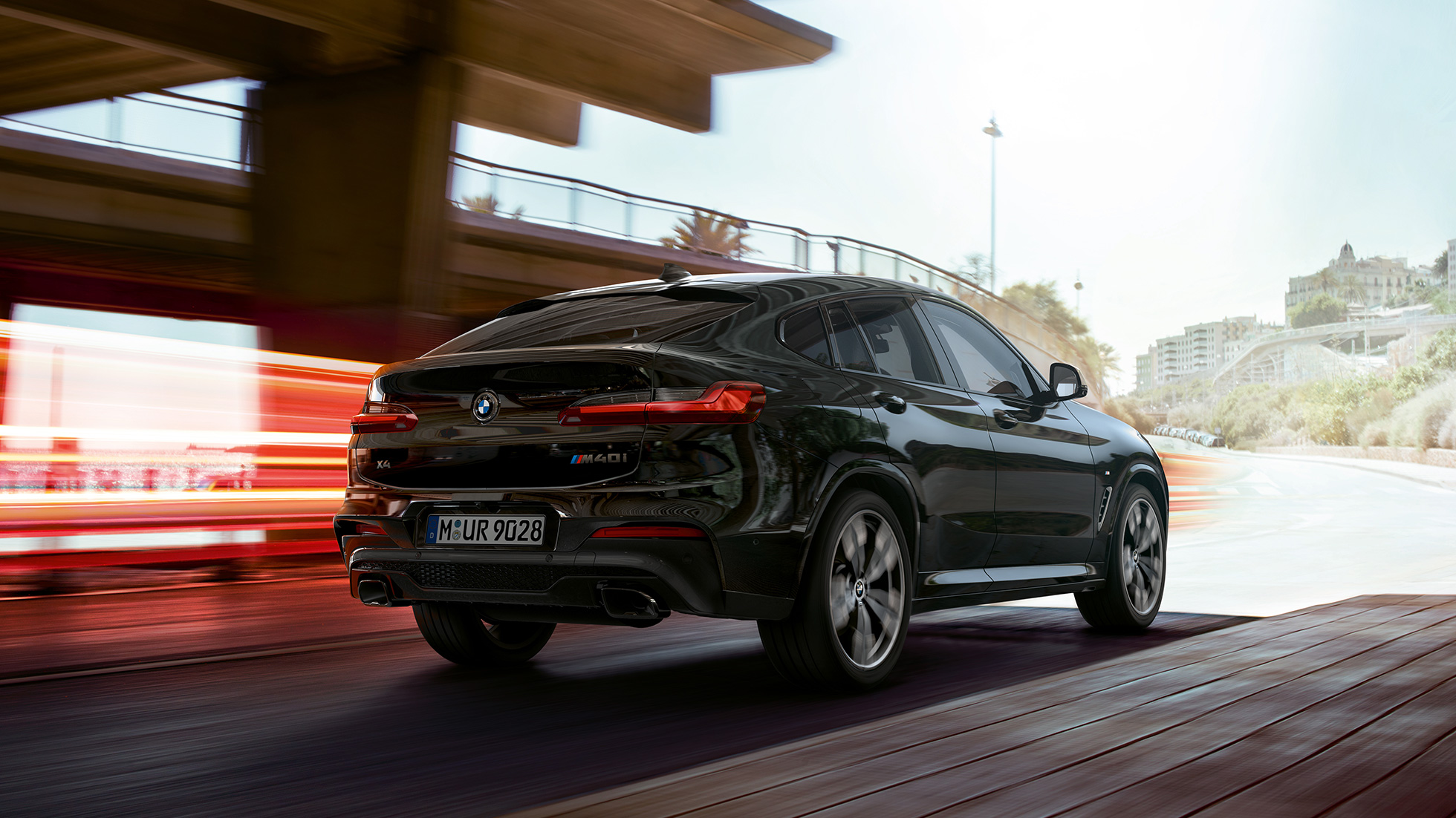 BMW X4 M40i, trīs ceturtdaļu skats no priekšpuses. BMW X4 M40i metāliskā Black Sapphire krāsā, braucošs, virsbūve, trīs ceturtdaļu skats no priekšpuses ar gaismas joslām.