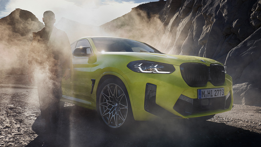 BMW X4 M Competition, F98, LCI, atjaunināts, 2021, Sao Paulo Yellow krāsa, trīs ceturtdaļu priekšpuses skats, ar vīrieti miglā