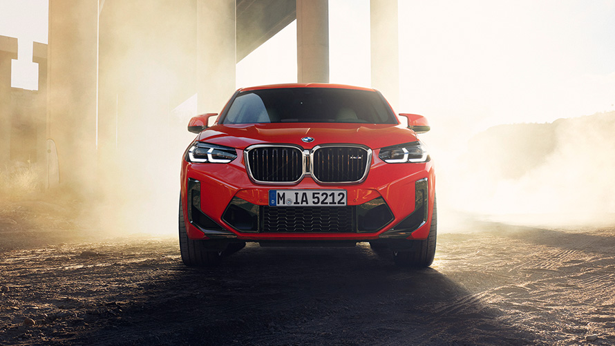 BMW X4 M, F98, LCI, atjaunināts, 2021, metāliska Toronto Red krāsa, priekšpuses skats, uz tilta kolonnu fona