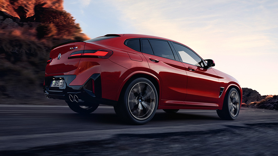 BMW X4 M, F98, LCI, atjaunināts, 2021, metāliska Toronto Red krāsa, trīs ceturtdaļu aizmugures skats, braucienā pa ceļu