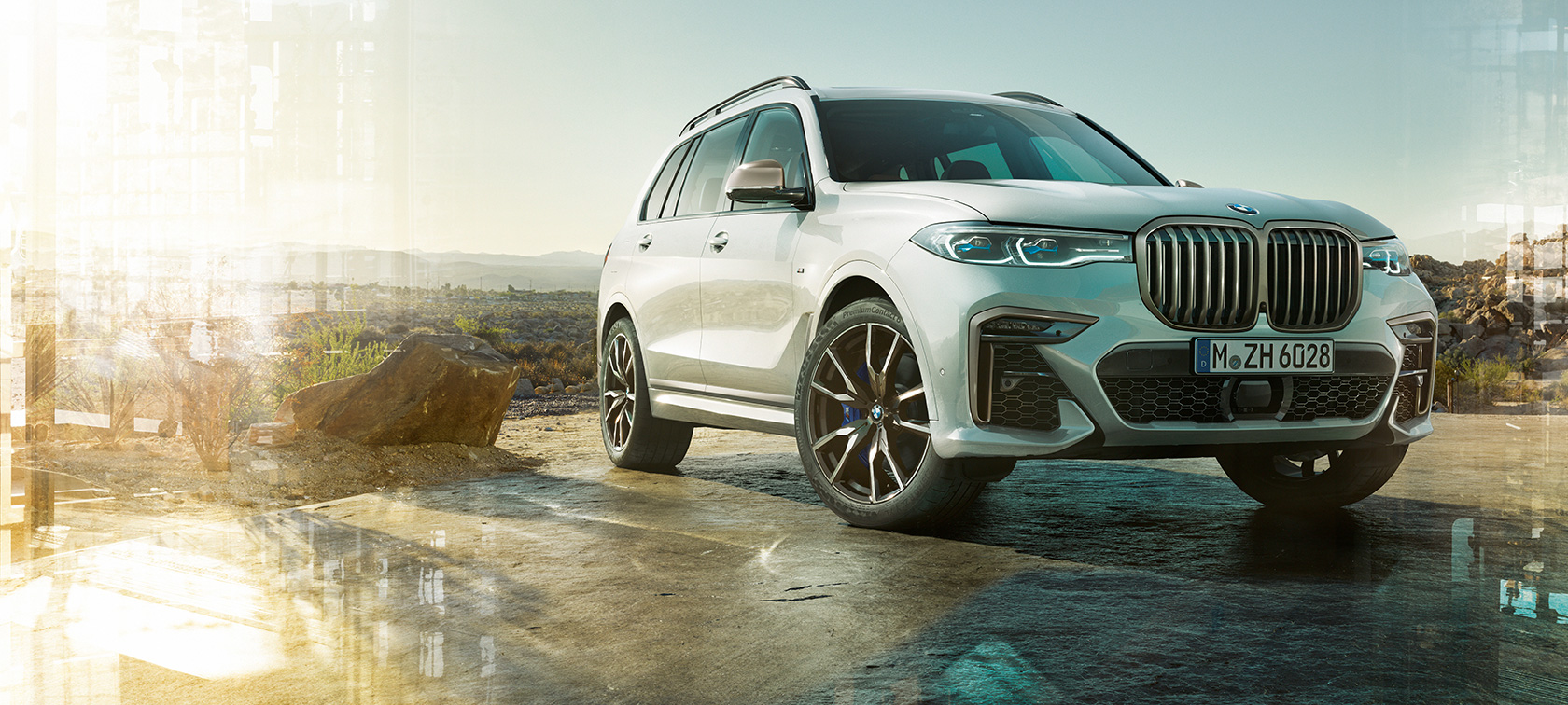 BMW X7 M automobilis, priekšpuse trīs ceturtdaļu skatā no kreisās puses BMW X7 M automobilis Mineral White krāsā, G07, stāvošs, priekšpuse trīs ceturtdaļu skatā no kreisās puses