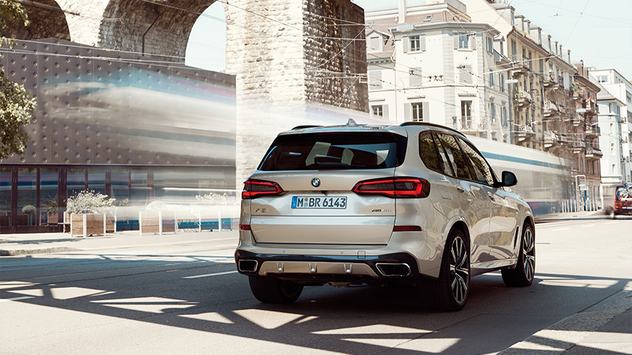 BMW X5, G05, ceturtā paaudze, trīs ceturtdaļu aizmugures skats, stāvošs automobilis uz ēkas fona BMW X sērija, BMW X5, G05, ceturtā paaudze, trīs ceturtdaļu aizmugures skats, stāvošs automobilis uz ēkas fona