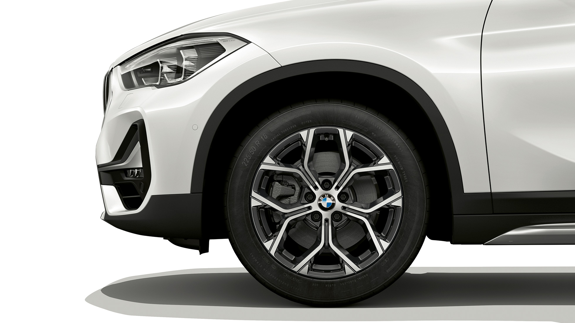 BMW X1, xLine modelis, vieglmetāla disks. BMW X1, xLine modelis, skats no sāniem ar vieglmetāla diska tuvplānu.