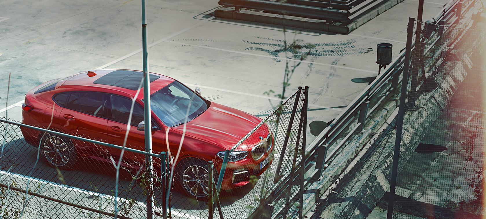 BMW X4 novietots stāvvietā BMW X4 G02 2018, Flamenco Red krāsa ar mirdzuma efektu, novietota atklātā stāvvietā, skats no putna lidojuma