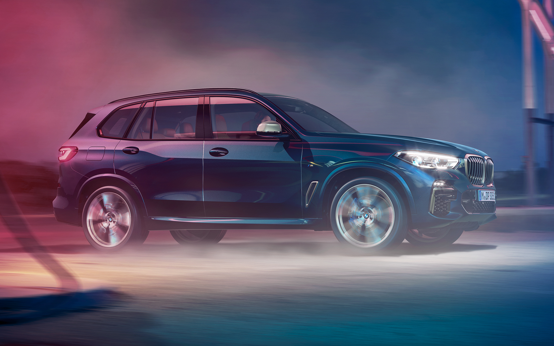 BMW X5 M50d kustībā BMW X5 M50d skats braucienā naksnīgā pilsētā