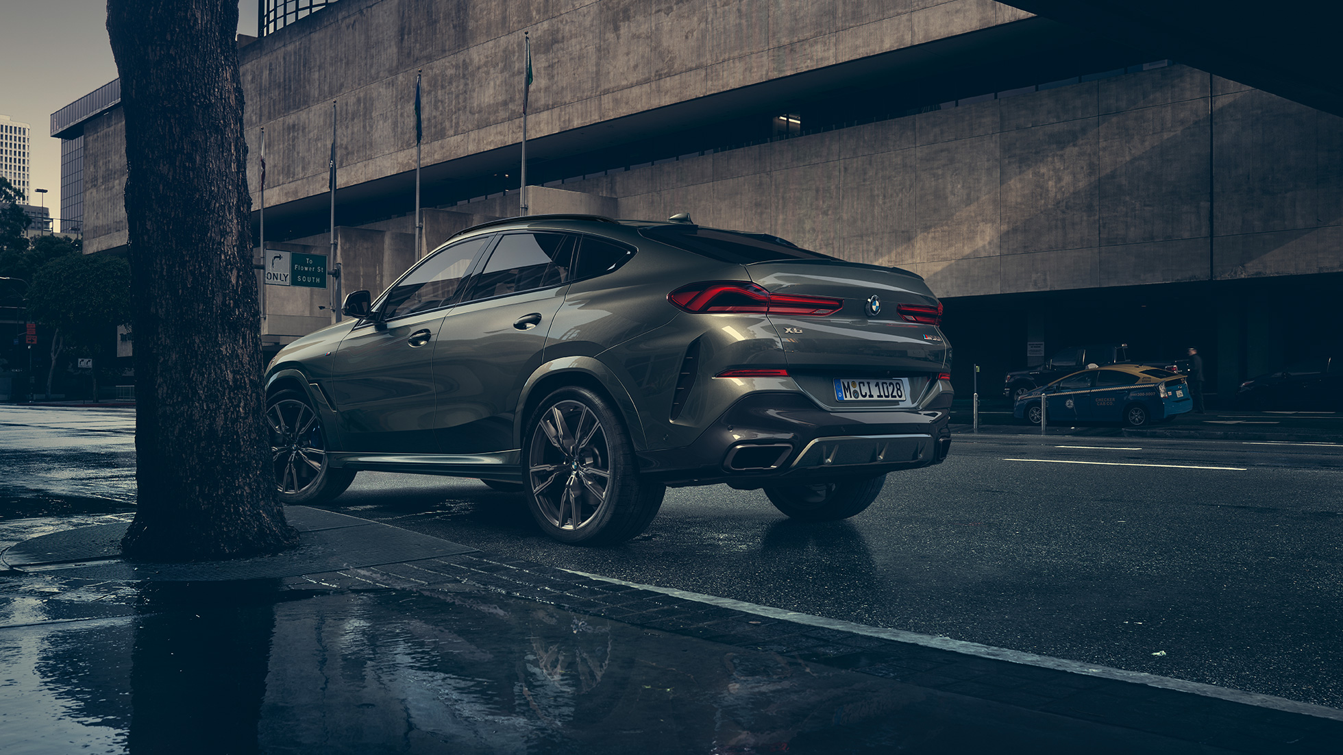 BMW X6 virsbūve. BMW X6 trīs ceturtdaļu skats no aizmugures uz pilsētas fona.