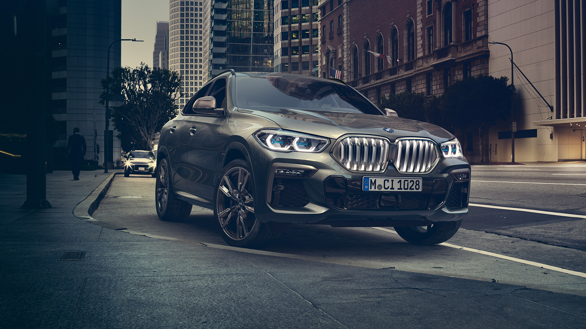 BMW X6 adaptīvā M balstiekārta Professional BMW X6 trīs ceturtdaļu skats no priekšpuses uz pilsētas fona.