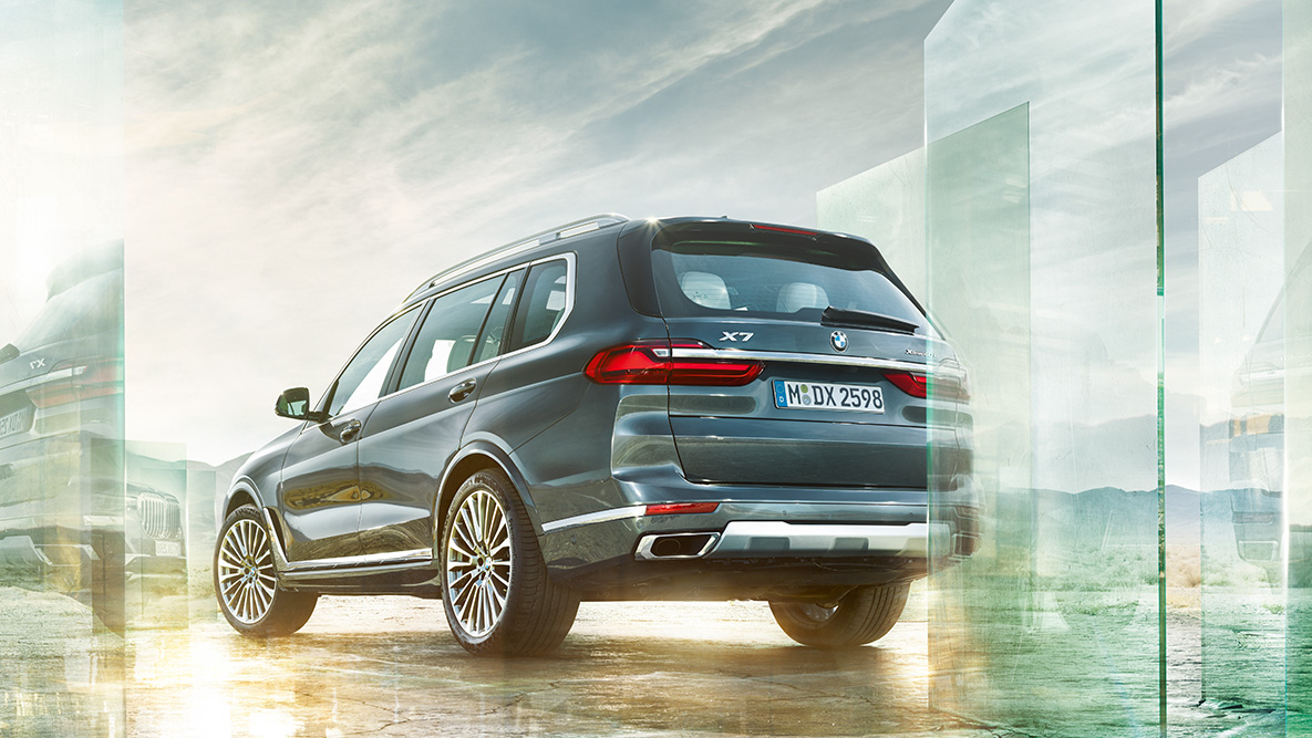 BMW X7 komforts un braukšanas dinamika BMW X7 trīs ceturtdaļu skats no aizmugures uz abstrakta fona