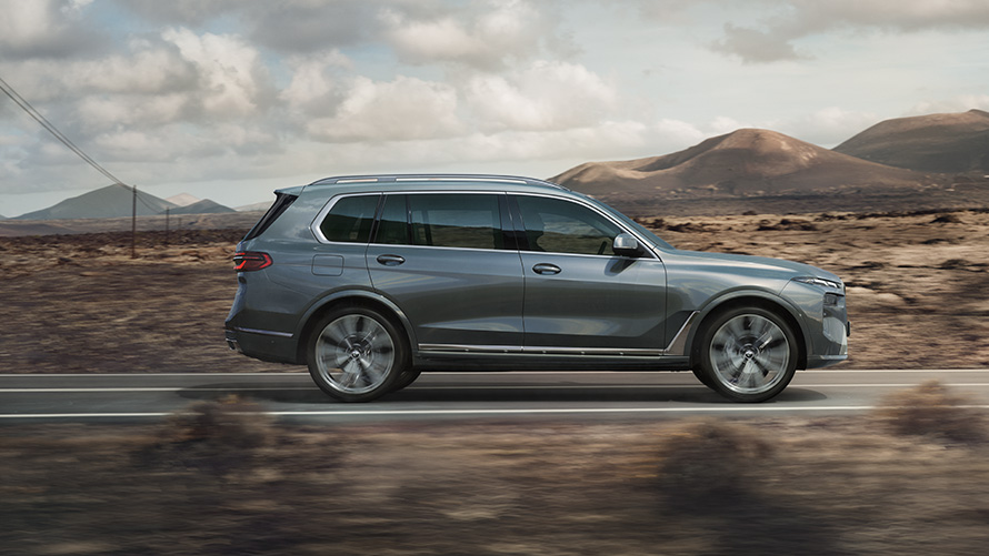 BMW X7, G07, LCI, sānskats, metāliska Sparkling Copper Grey krāsa BMW X7, G07, LCI, sānskats, braucienā, metāliska Sparkling Copper Grey krāsa