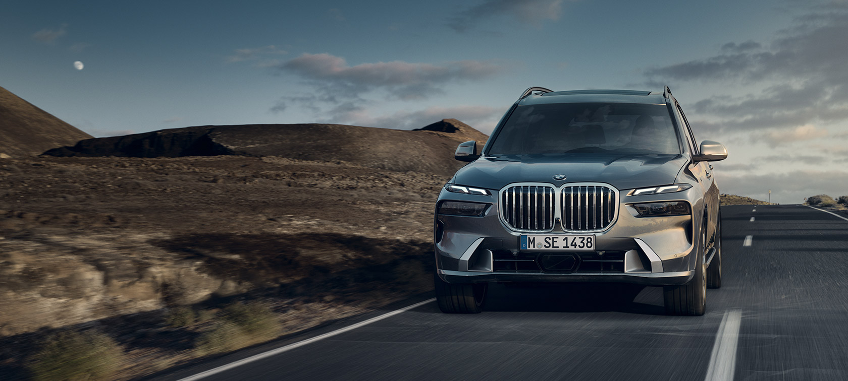 BMW X7, G07, LCI, septiņu astotdaļu priekšpuses skats, braucienā, metāliska Sparkling Copper Grey krāsa, Pure Excellence dizains