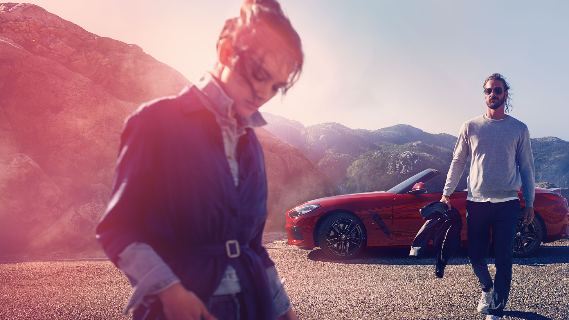 BMW Z4 Roadster uz kalnu fona Vīrietis un sieviete un BMW Z4 Roadster uz kalnu fona