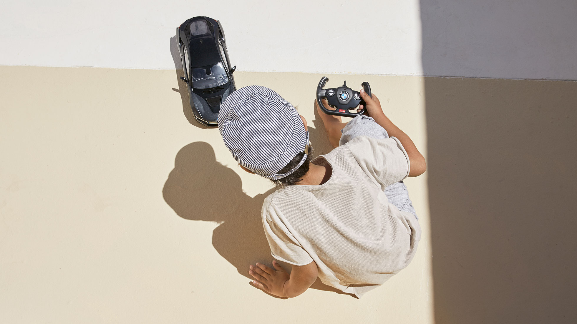 Miniatūrs RC BMW i8. Zēns aizrautīgi spēlējas ar tālvadības miniatūru RC BMW i8.