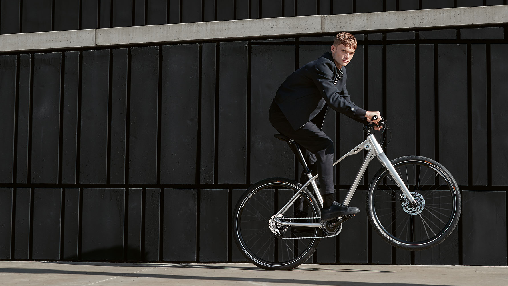 Vīrietis izbrauc līkumu ar BMW Cruise velosipēdu. Vīrietis izbrauc līkumu ar BMW Cruise velosipēdu.