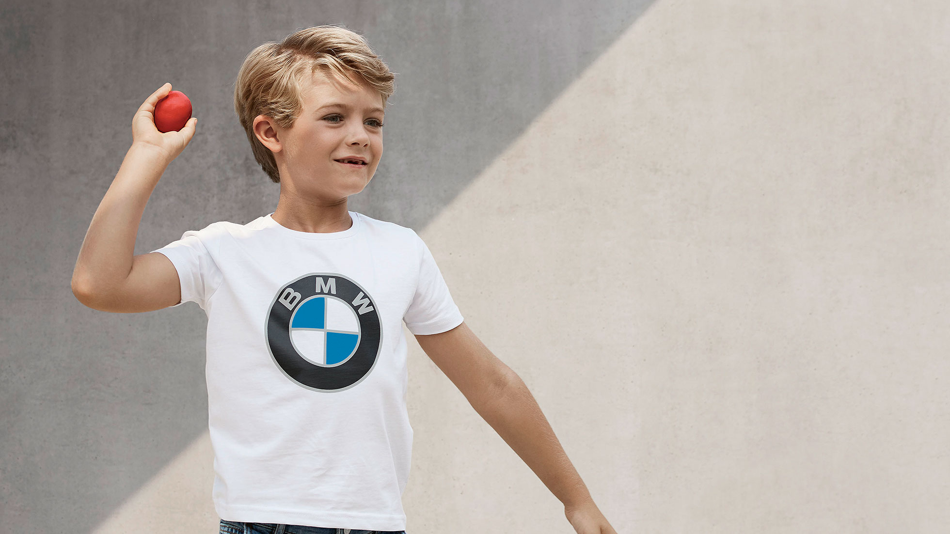 BMW bērnu kolekcija. Puika tērpies BMW bērnu kolekcijas apģērbā un aksesuāros.