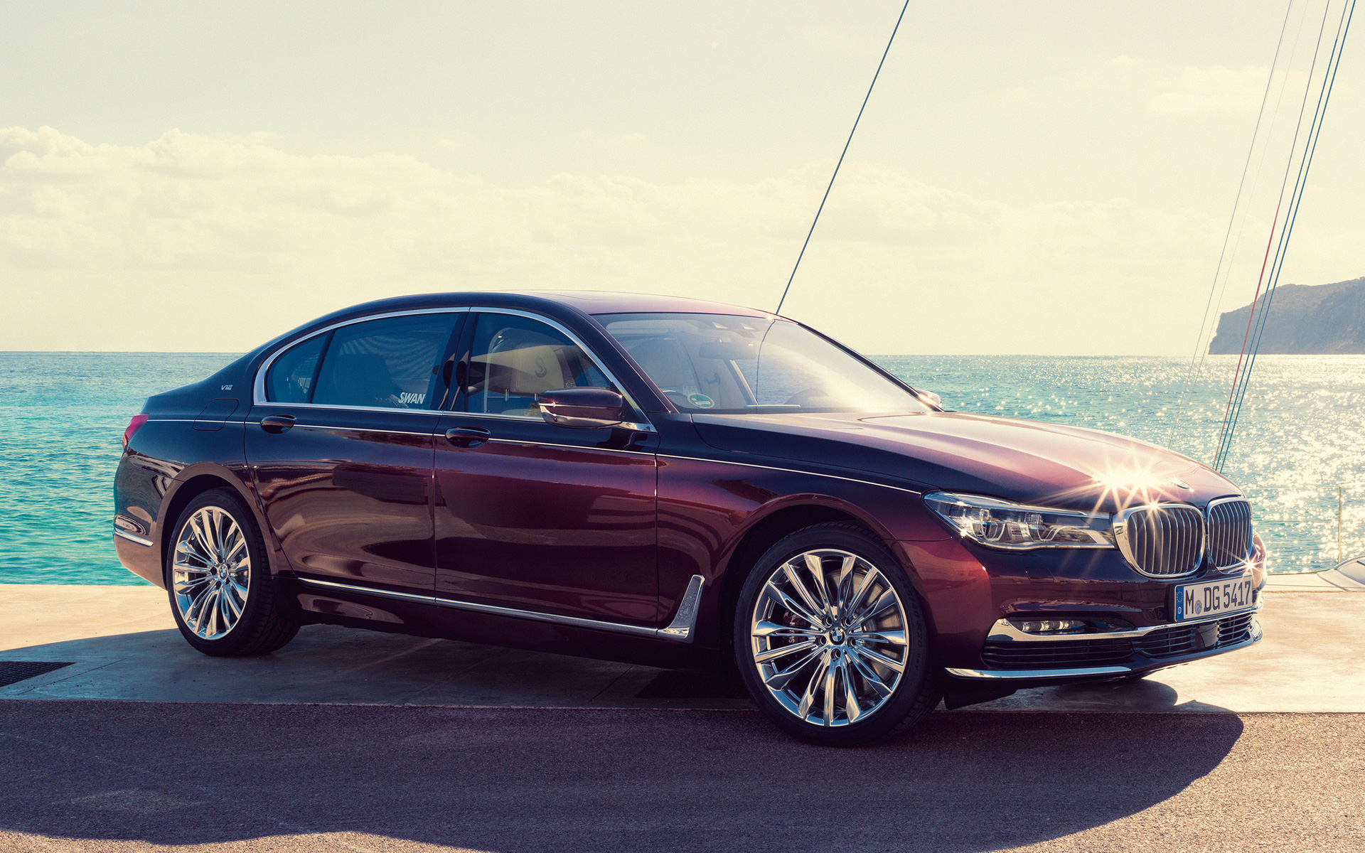 BMW Individual M760Li, ko iedvesmojis Nautor’s Swan, G12, 2017, uz buru jahtas fona BMW Individual M760Li, ko iedvesmojis Nautor’s Swan, G12, 2017, trīs ceturtdaļu sānskats, stāvošs automobilis uz muliņa, uz buru jahtas fona līcī