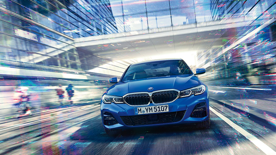 Skats uz zilu BMW braucienā Skats uz zilu BMW braucienā ar stikla pāreju fonā