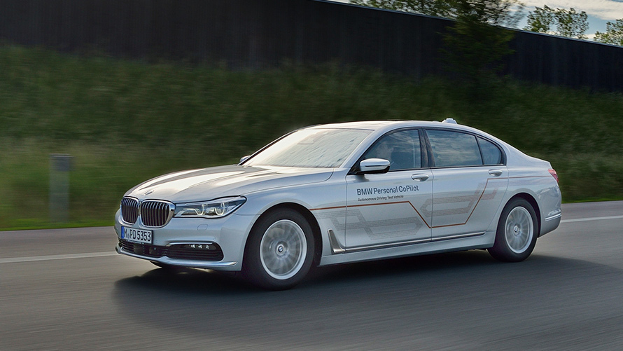 Pelēks BMW BMW 7. sērijas Sedan Pelēks BMW 7. sērijas Sedan braucienā pa tiltu ar apvārsni fonā