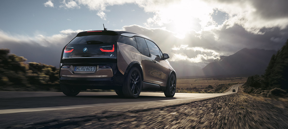 BMW i3s uz kalnu ainavas fona BMW darbības attāluma piemērs, BMW i3s uz kalnu ainavas fona, trīs ceturtdaļu aizmugures skats
