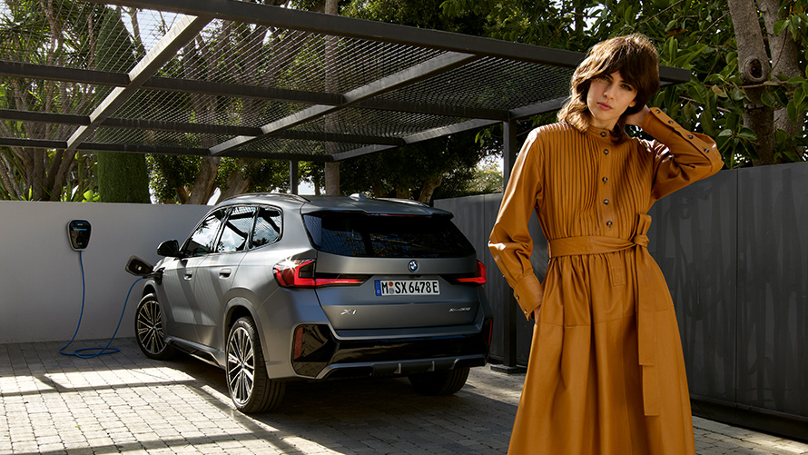 BMW X1, hibrīdauto, 2022, U11, aizmugures skats, uzlādes laikā ar modeli BMW X1, hibrīdauto, 2022, U11, aizmugures skats, uzlādes laikā ar modeli