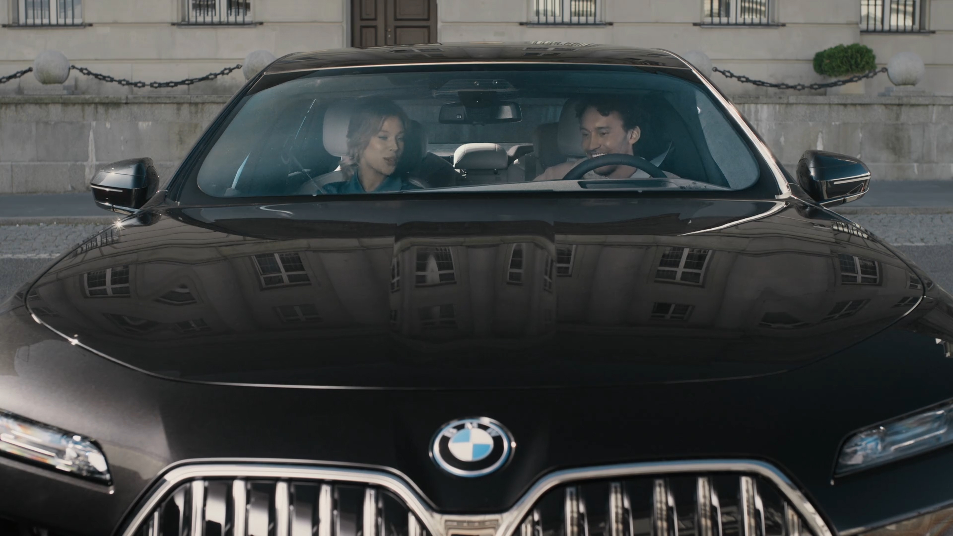 BMW iDrive izaicinājums, ievērojamu vietu apskatīšana BMW iDrive izaicinājums, ievērojamu vietu apskatīšana, G70, pretskats, divas personas skatās BMW izliektajā displejā