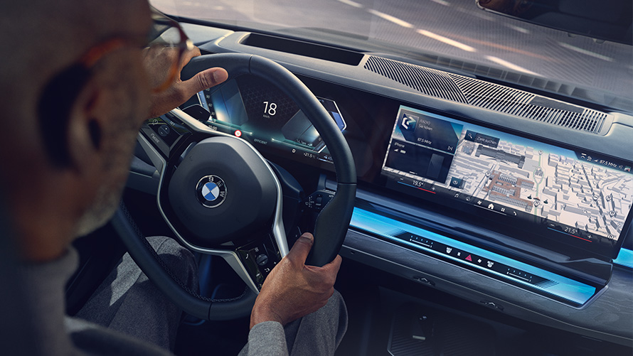 BMW salons, vīrietis skatās displejā ar operētājsistēmu 8.5 BMW salons, vīrietis skatās uz BMW kartēm displejā ar operētājsistēmu 8.5