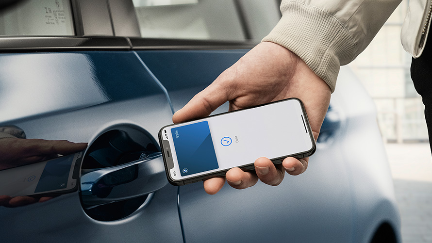 Digitālā atslēga Vīrietis ar viedtālrunī esošo digitālo atslēgu atver BMW