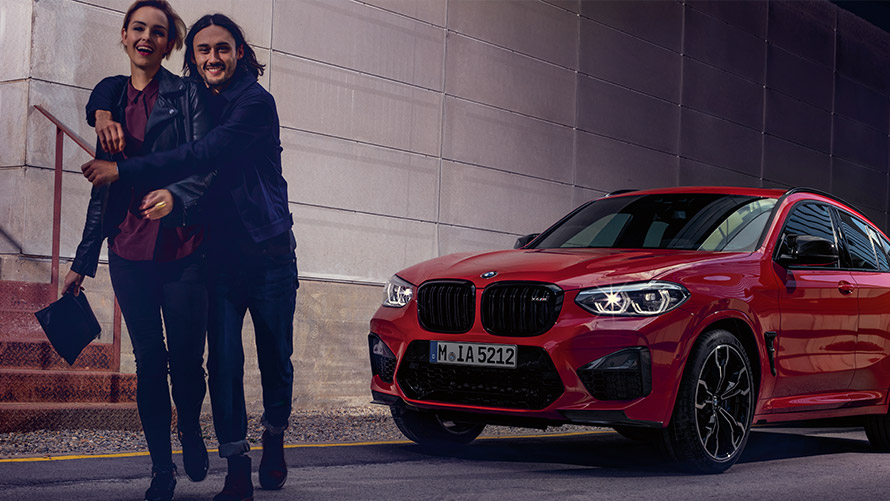 Sieviete un vīrietis smejas uz BMW automobiļa fona BMW Financial Services, BMW līzings, vīrietis un sieviete smejas uz BMW automobiļa fona