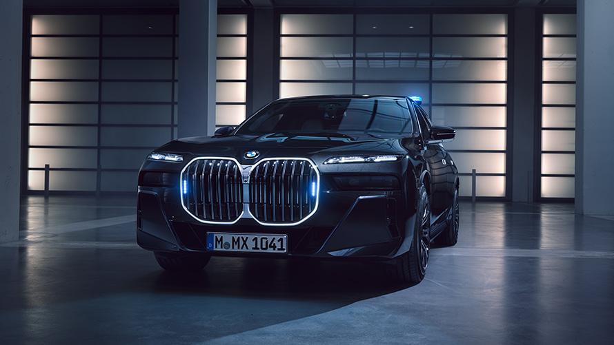Skats no priekšas uz BMW 7. sērijas Protection G73 ar ieslēgtiem pagrieziena signāla lukturiem Skats no priekšas uz stāvvietā novietotu BMW 7. sērijas Protection G73 ar ieslēgtiem pagrieziena signāla lukturiem