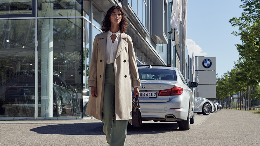 BMW Service Inclusive Sieviete uz BMW automobiļu pārstāvniecības fona