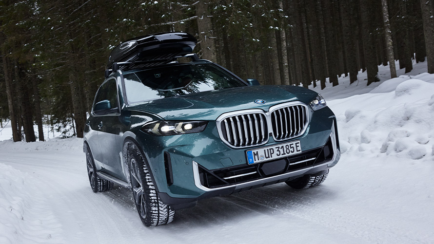 BMW X5 (G05 LCI) ar BMW ziemas riteņu komplektu uz sniega klāta ceļa mežā BMW X5 (G05 LCI) ar BMW ziemas riteņu komplektu uz sniega klāta ceļa mežā