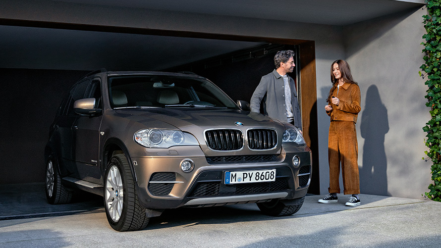 BMW novietots uz garāžas fona ar modeļiem BMW Value Service, BMW novietots uz garāžas fona ar modeļiem