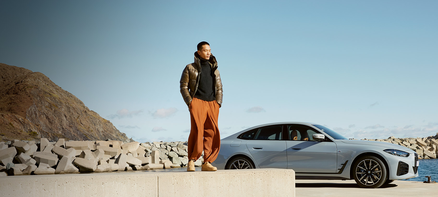 BMW Service Inclusive BMW Service Inclusive, vīrietis uz BMW i4 fona piekrastē