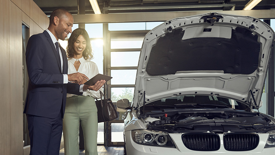 Pārbaude un apkope BMW servisa klients un BMW servisa darbinieki apspriež pārbaudi un apkopi