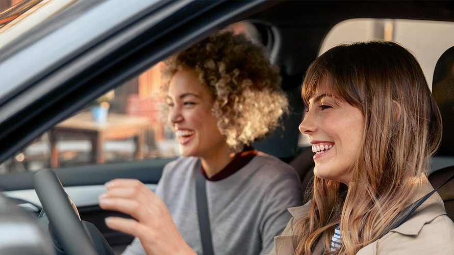 BMW braukšanas prieks ar BMW pakalpojumiem Divas priecīgas sievietes savos BMW