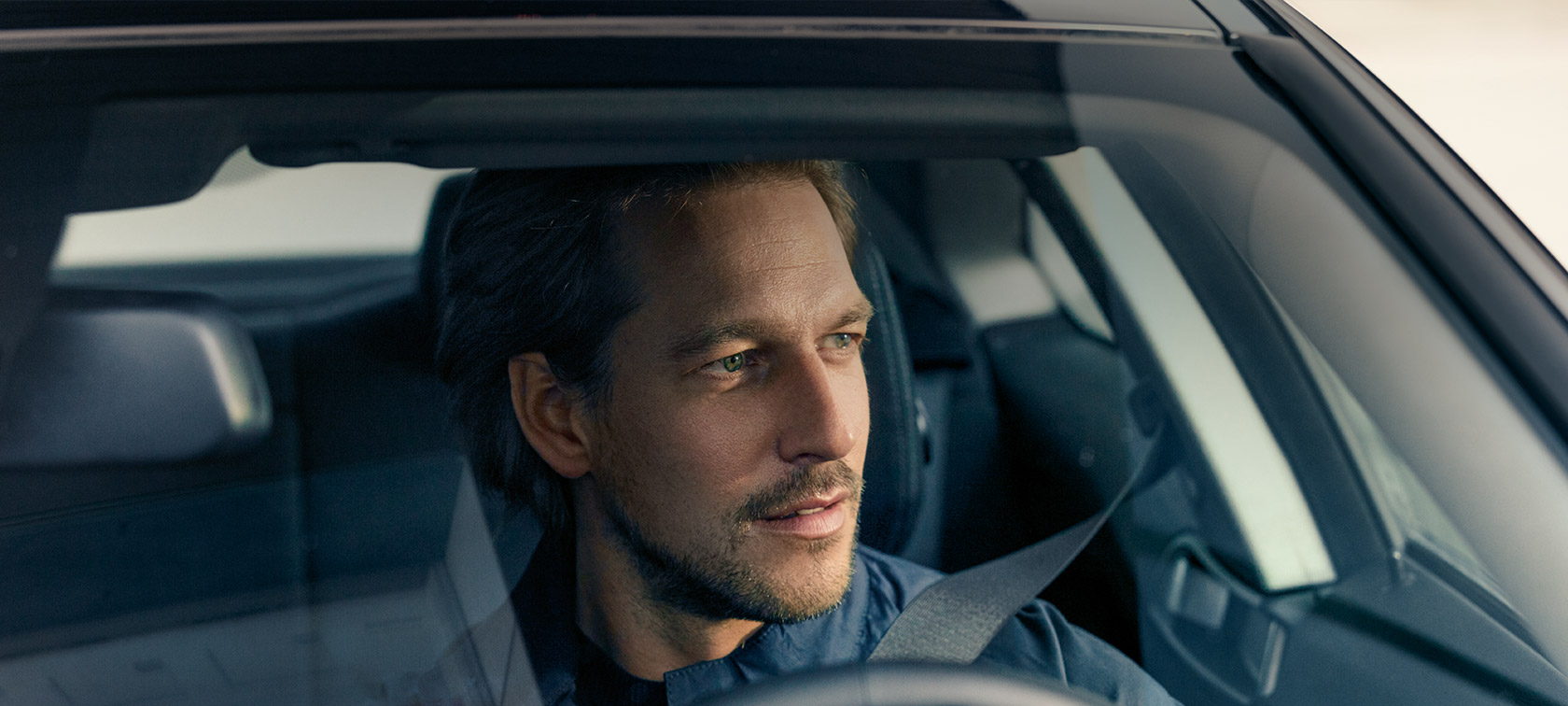Vīrietis vada BMW, pateicoties BMW Service Inclusive BMW Service Inclusive, vīrietis vada BMW, skatoties cauri vējstiklam