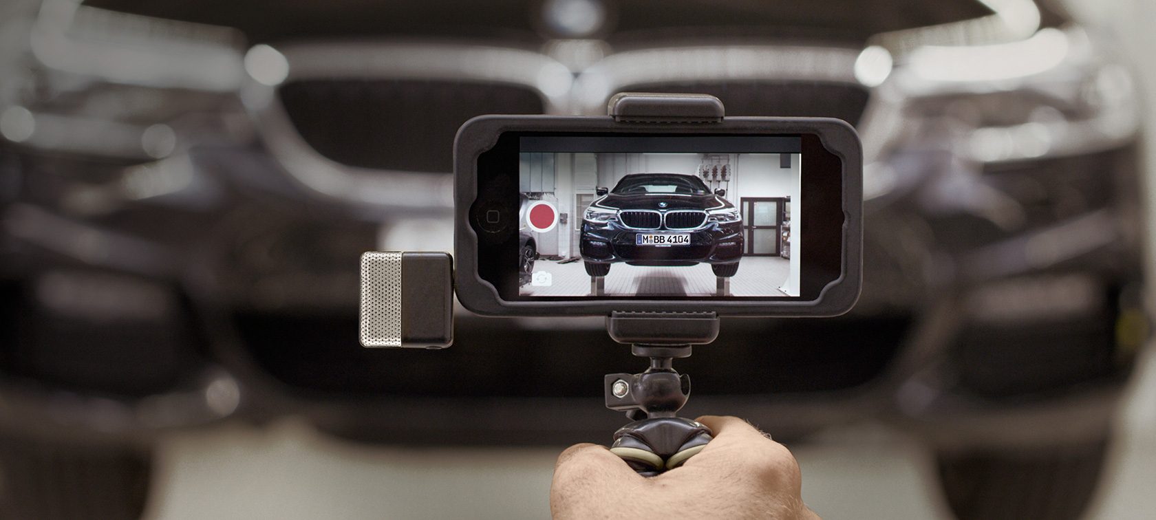 BMW servisa video viedtālruņa ekrānā BMW servisa video viedtālruņa ekrānā uz BMW fona