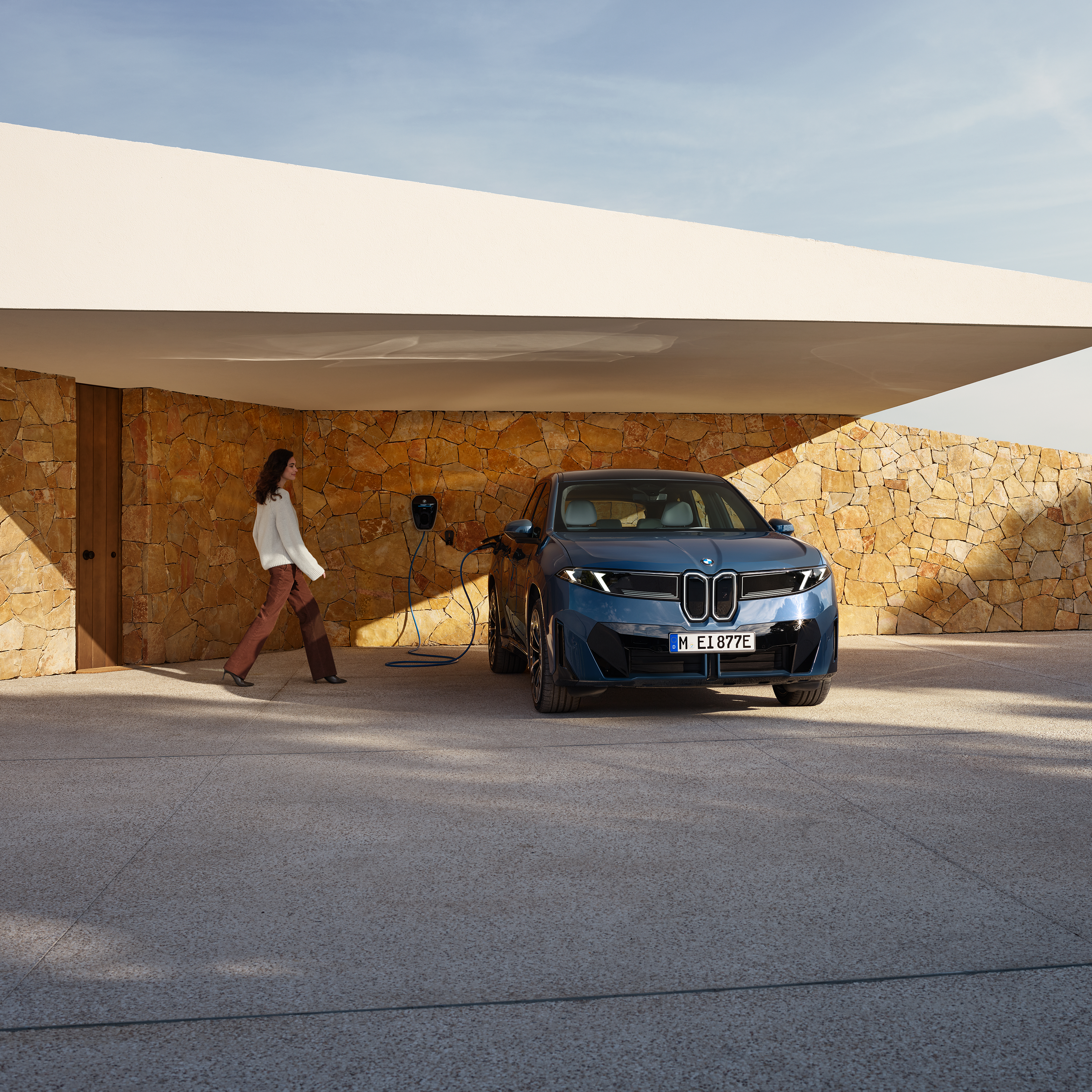 Sieviete dodas uz BMW iX3, kas pievienots Wallbox