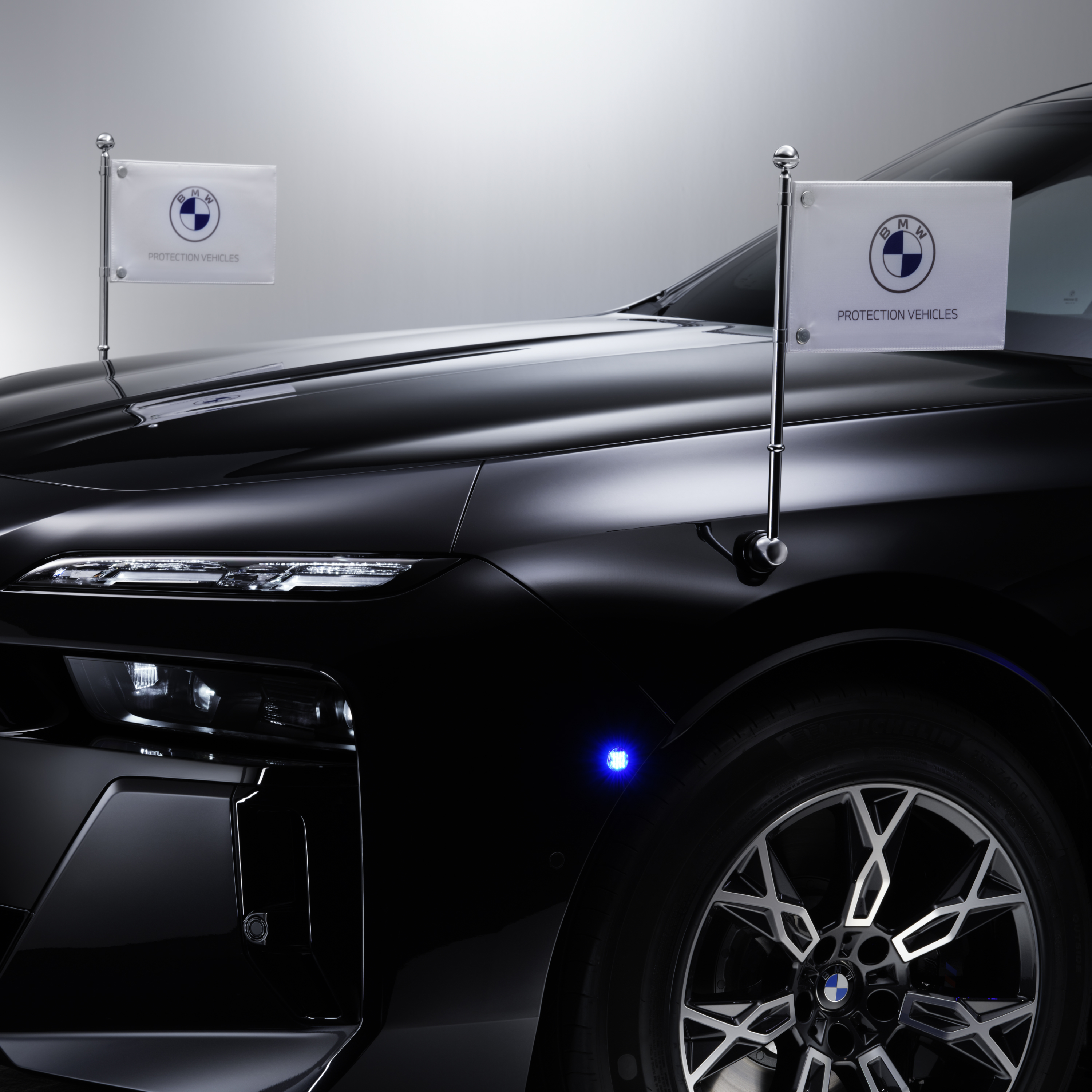 BMW ar diviem karogu turētājiem priekšpusē