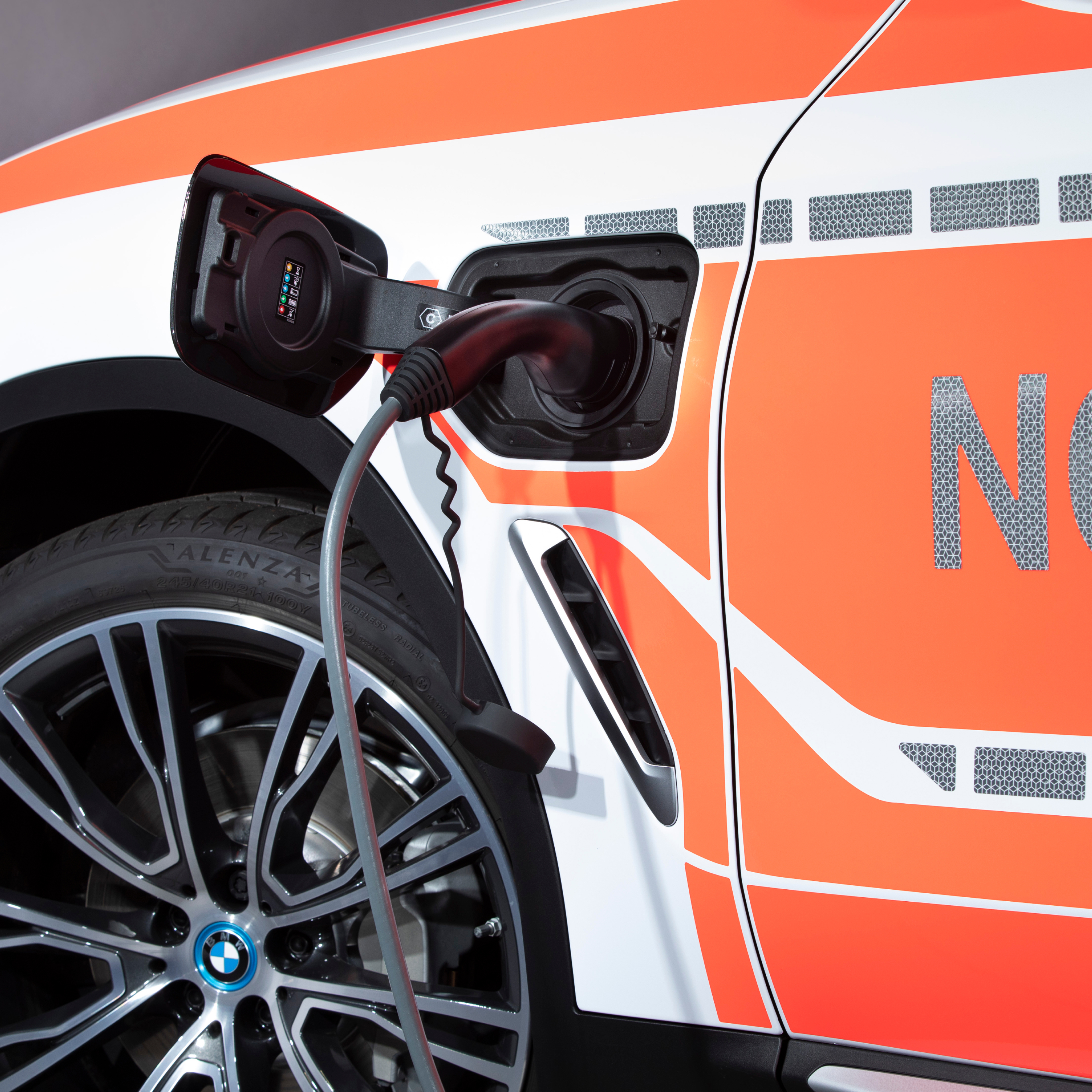 BMW operatīvais transportlīdzeklis uzlādējama hibrīdauto konfigurācijā tiek uzlādēts; uzlādes kabeļa tuvplāns